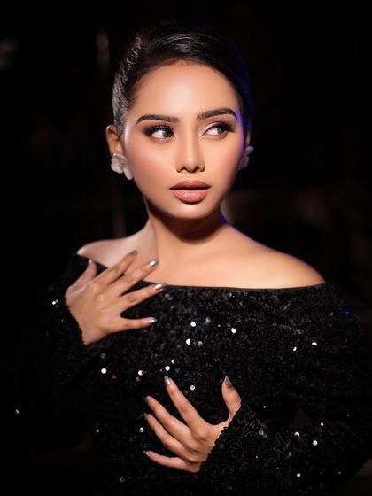 A classic portrait in a black off-shoulder sequined top, showcasing a sophisticated and elegant makeup look.