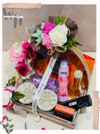 This personalized gift hamper is designed to make her smile. It's a beautiful arrangement of cosmetics from brands like Nykaa and MAC, along with decorative elements.