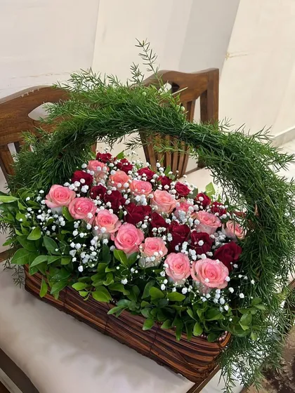 A side view of our rose basket, showing the beautiful arch of the handle made entirely of fresh greens. This is a truly unique and impressive floral gift.