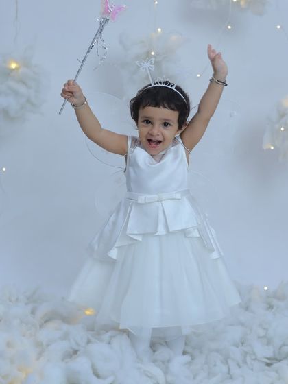Spreading her wings and fairy magic! This little girl is full of joy and energy in our fairy-themed photoshoot, complete with wings and a magic wand.