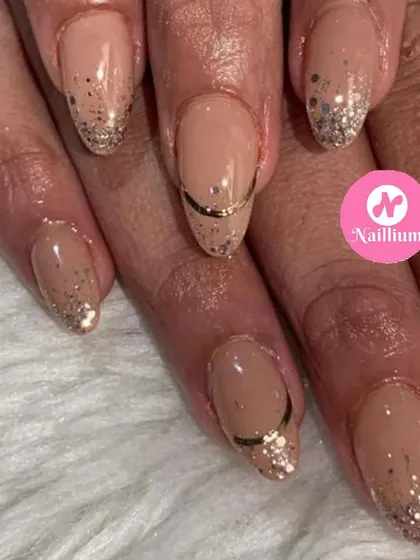 A sophisticated wedding season look with a nude base, gold glitter fade, and a delicate gold accent line.