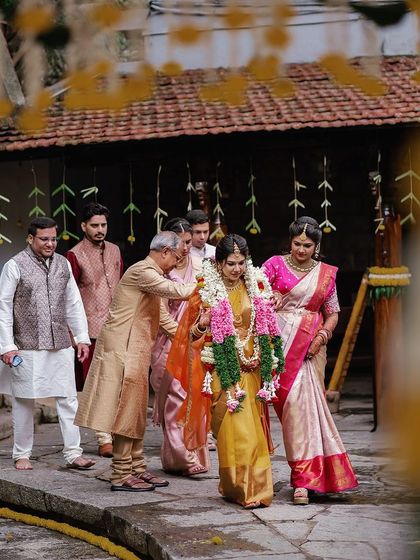 The bride's procession, a beautiful and emotional moment as she walks towards the mandap with her family.