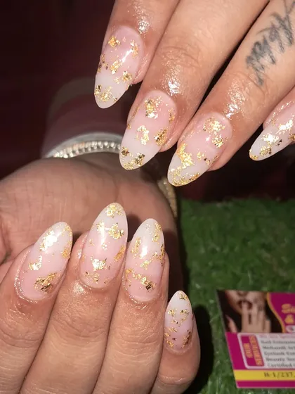 A close-up of these beautiful nails with delicate gold foil flakes scattered over a milky white base.