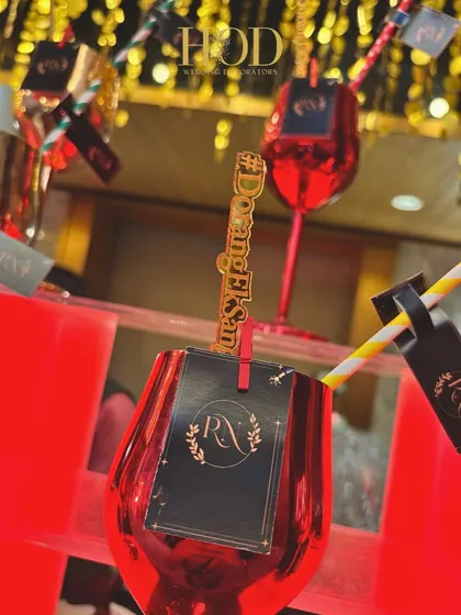 A close-up of a personalized drink stirrer with the couple's hashtag, a small but impactful detail for a cocktail night.