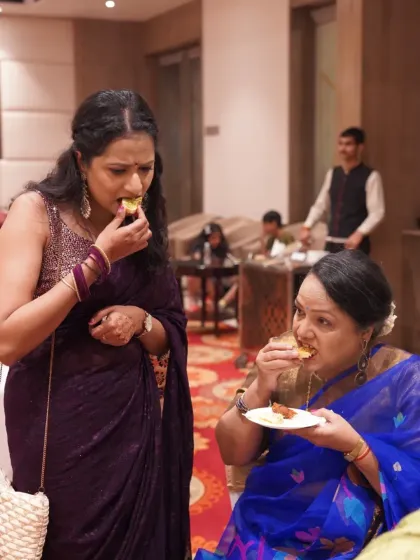 Two guests fully enjoying the wedding feast. These are the real, relatable moments that everyone will look back on and smile.