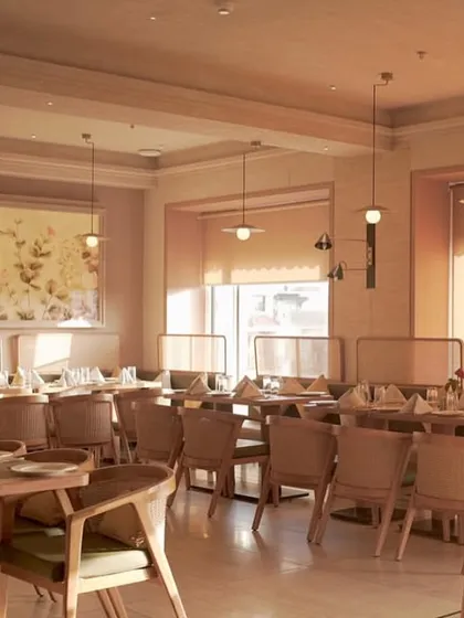 A wider view of the restaurant, showing how the nature-inspired floral artworks complement the sophisticated and warm ambiance.
