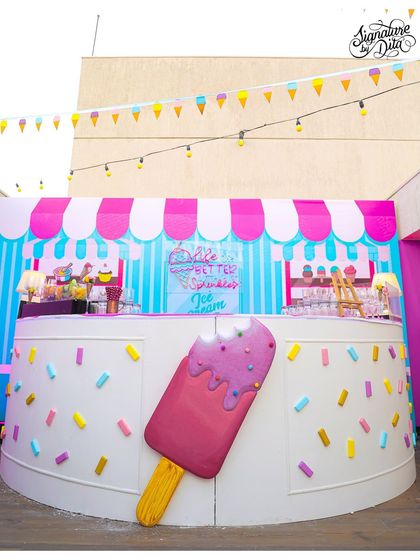 I designed this custom bar to look like an ice cream counter, complete with a giant melting popsicle prop and a sprinkle-covered facade.