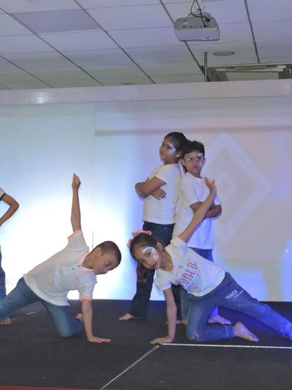 A group of students strikes a final pose at the end of their graceful dance performance, showcasing their coordination and stage presence.