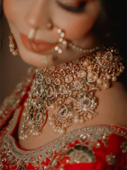 A detailed close-up of a bride's elaborate kundan and pearl necklace, showcasing the craftsmanship of her wedding jewelry.