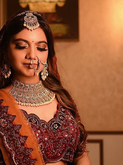 A serene portrait of a bride in a deep red lehenga, capturing a moment of quiet contemplation.