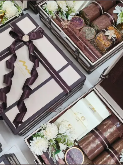A close-up of our wedding trunk boxes, highlighting the rich brown and cream color scheme and the beautiful ribbon details. These hampers are filled with premium items, perfect for making a lasting impression.
