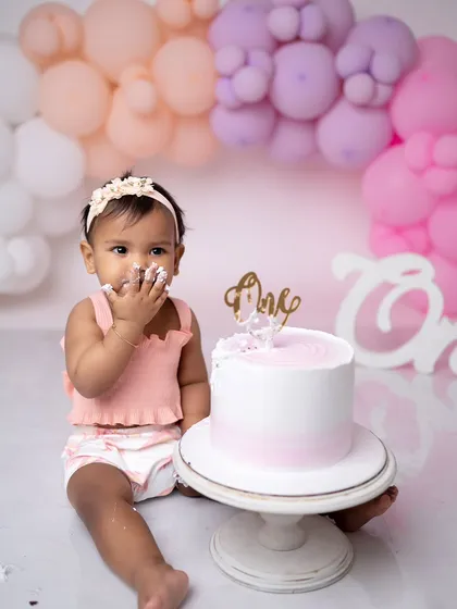 A close-up of the birthday girl getting her first taste of frosting. These are the moments that make cake smash photography so special.