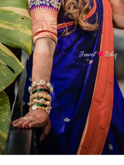 A close-up on the bride's arm, showing the stack of traditional green bangles mixed with my gold-plated Temple Jewellery kadas.