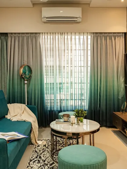 Another angle of the living room, highlighting the comfortable sofa and layered coffee tables. The design focuses on creating a functional and relaxing environment.