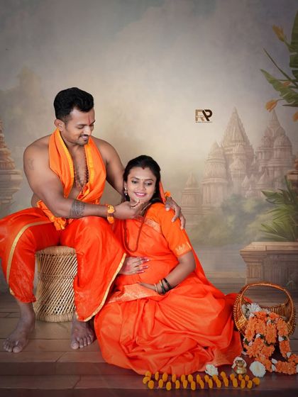 A tender moment captured in our Seetha-Ram themed maternity shoot. The husband-to-be lovingly touches his wife's chin, both dressed in vibrant orange traditional attire.
