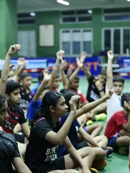 We focus on more than just physical skill. This image shows our young players actively participating in our 'Unlock your Confidence' workshop, learning about emotional management and mental resilience to improve performance on and off the table.