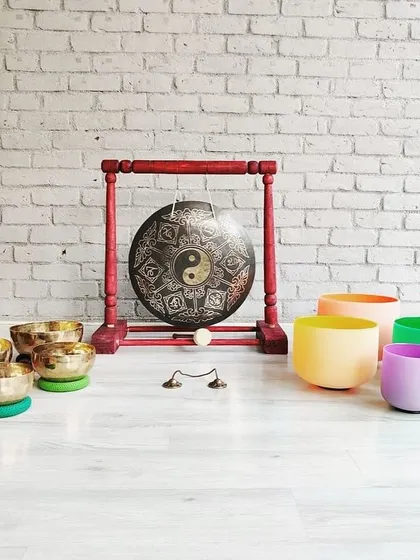 My shala is home to a wide array of sound healing instruments. This setup includes a collection of hand-hammered Tibetan bowls, colorful chakra-tuned crystal bowls, and a Yin-Yang gong, each with its own unique voice and healing properties.