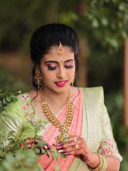 This bride chose a lovely pastel pink and green saree for her ring ceremony. The makeup is soft and romantic, with pink tones on the eyes and lips to match her outfit.