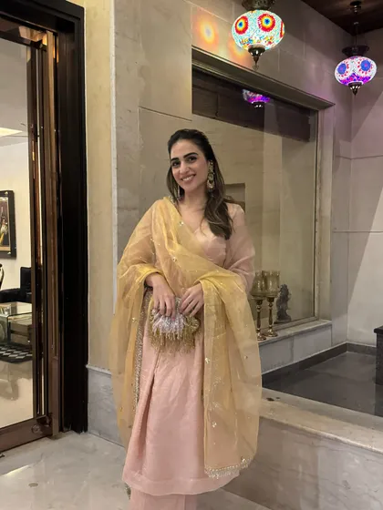 A lovely peach suit set with a golden organza dupatta. This look is perfect for Diwali parties or other festive occasions that call for understated elegance.