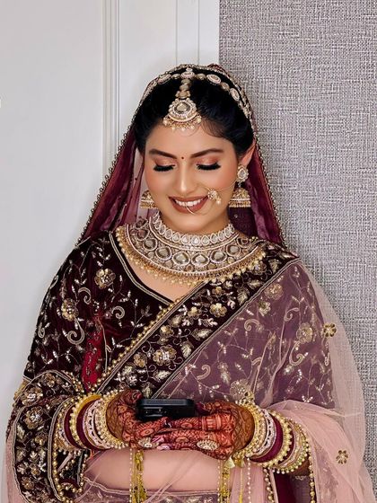 A happy, candid moment of the bride checking her phone. Her makeup is flawless even in a casual moment, showcasing the longevity and finish of the HD makeup I use.