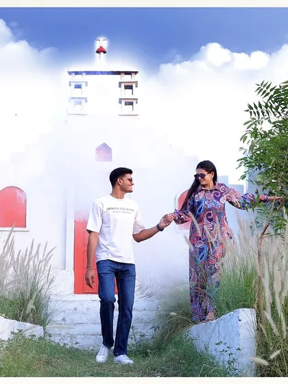 A beautiful daytime shot at our Santorini-themed set, showcasing the clean white walls and pops of red against a natural, grassy foreground.