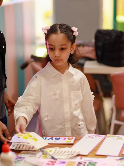 A young guest works on a creative name-card activity at our craft station. We offer a variety of hands-on activities to keep little hands busy.