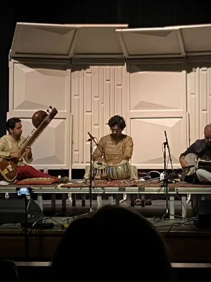 A wide shot of the stage at St. Helena, California, with Alam Khan bhai on sarod and Arjun Verma bhai on sitar. A powerful trio of string instruments and percussion.