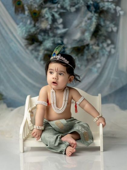 A happy little Krishna, sitting on a tiny bed. The blue and silver setup is a beautiful variation on the theme.
