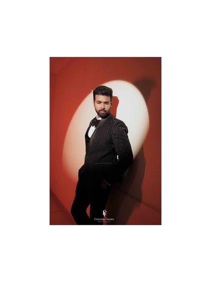 A solo shot of the groom in a classic tuxedo, looking sharp and ready for the reception.