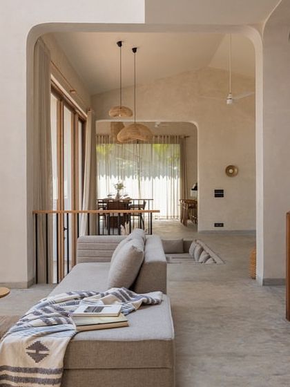 This view of the House of Basho shows the transition between different levels and spaces. The open design, soft arches, and consistent material palette create a harmonious flow throughout the home.