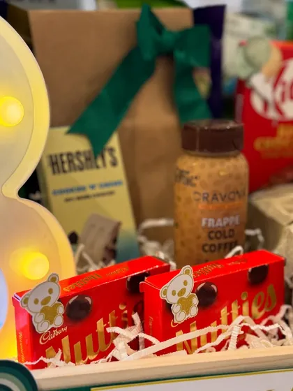 A detail shot focusing on the sweet treats, including Cadbury Nutties and Hershey's, nestled beside the glowing '3'.