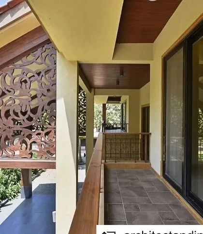 The balcony of the Khandala villa, featuring an intricately carved wooden screen that provides privacy while allowing for ventilation and light.