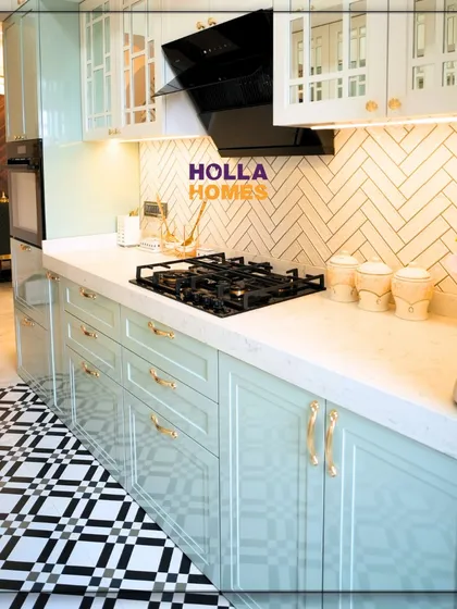 The cooking area of the vintage kitchen, featuring a modern black chimney and hob set against a classic white tile backsplash. The patterned floor adds a bold, graphic element to the space.