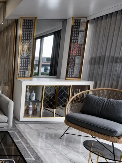 This image captures a custom-designed bar and console unit in a Goregaon West residence. The piece features white and gold accents, mirrored surfaces, and integrated lighting, serving as a functional and elegant focal point in the living room.