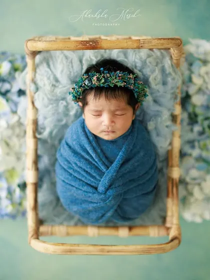 Wrapped snugly in blue, this newborn rests in a rustic basket surrounded by hydrangeas. This top-down angle is perfect for creating a beautiful, frame-worthy piece of art.