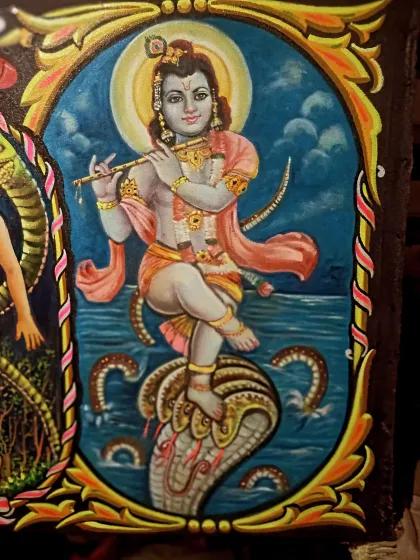 A painting of Lord Krishna playing his flute after conquering the serpent Kaliya, a famous story from Hindu mythology.