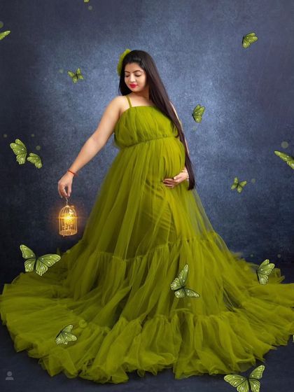 A magical, creative studio portrait featuring the lime green ball gown. The added butterfly effects and lantern prop create a whimsical and enchanting scene.