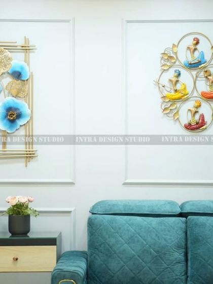 A close-up of the feature wall, showing the beautiful metal art pieces that serve as a focal point. The small Buddha statue and plant add a sense of tranquility to the space.
