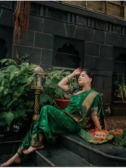 A confident and graceful pose. The bride looks stunning in her traditional green saree, her poise and beauty captured perfectly.