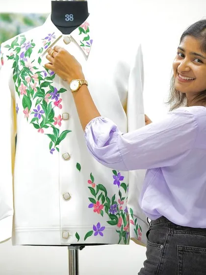 Here I am, adding the finishing touches to a floral Lachka suit. I spent over six hours meticulously painting these flowers to bring the designer's vision to life, and the floral collar was the final touch that completed the piece.
