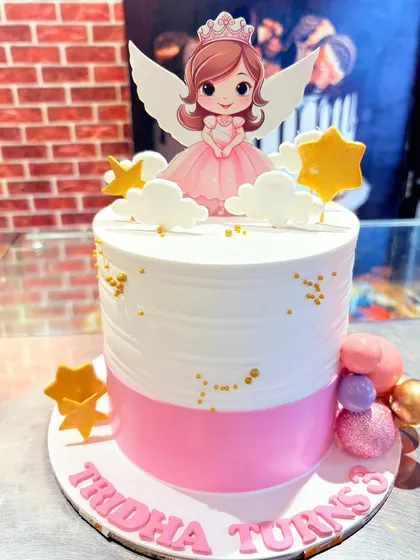 A pink and white angel princess cake, decorated with stars and clouds.