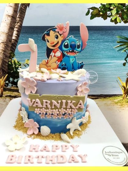 A tropical Lilo & Stitch cake. This design captures the beachy vibe of the movie with Lilo and Stitch sitting on an edible sandy shore.