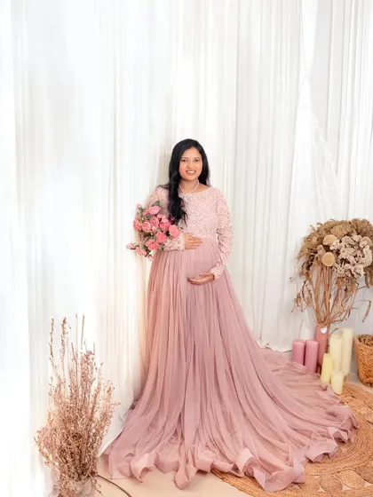 For the love of new life. This mother-to-be looks like a goddess in a beautiful pink gown, surrounded by soft, rustic decor.