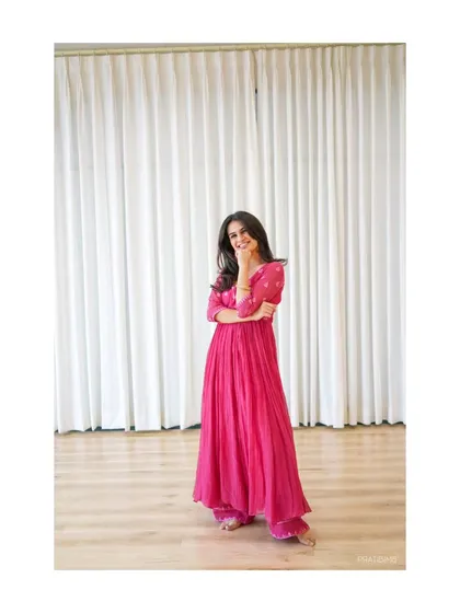 A candid shot from a photoshoot, capturing a moment of quiet joy. This look, in a pink anarkali, represents the grace and elegance of my semi-classical dance style.