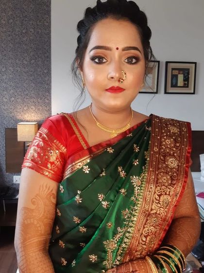 A full portrait of the bride in her green Paithani saree, complete with the traditional Maharashtrian nath and green bangles.