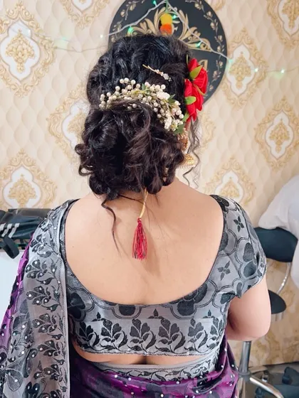 The back of a beautiful messy bun, decorated with a combination of red roses and baby's breath. This kind of floral arrangement adds a romantic touch to any updo.