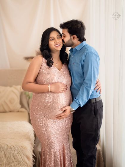A joyful and candid moment as a husband embraces his wife, both sharing a happy smile.