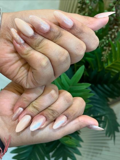 Another view of these elegant, pearlescent pink nails, showing off their stiletto shape.