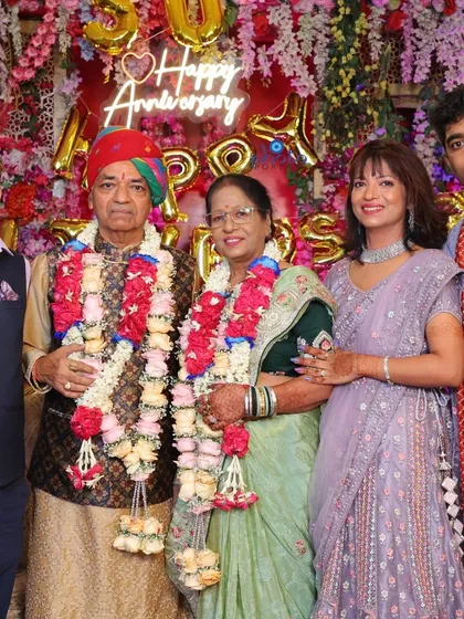 A family portrait with the celebrating couple at their 50th anniversary party, surrounded by their children and grandchildren.
