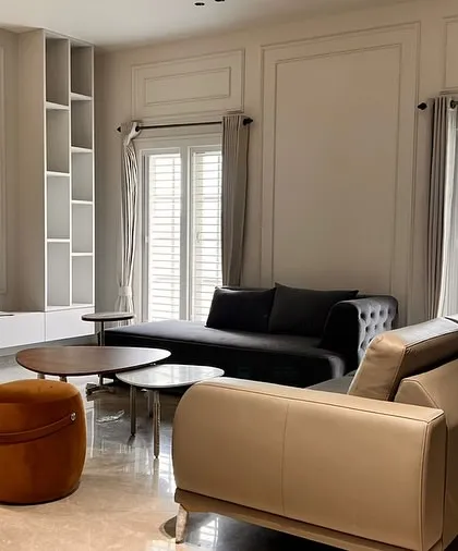 A contemporary living room setup for a client, featuring our uniquely curved dark sofa, a contrasting leather sofa, and vibrant velvet ottomans. This project showcases our ability to work with diverse forms and materials.